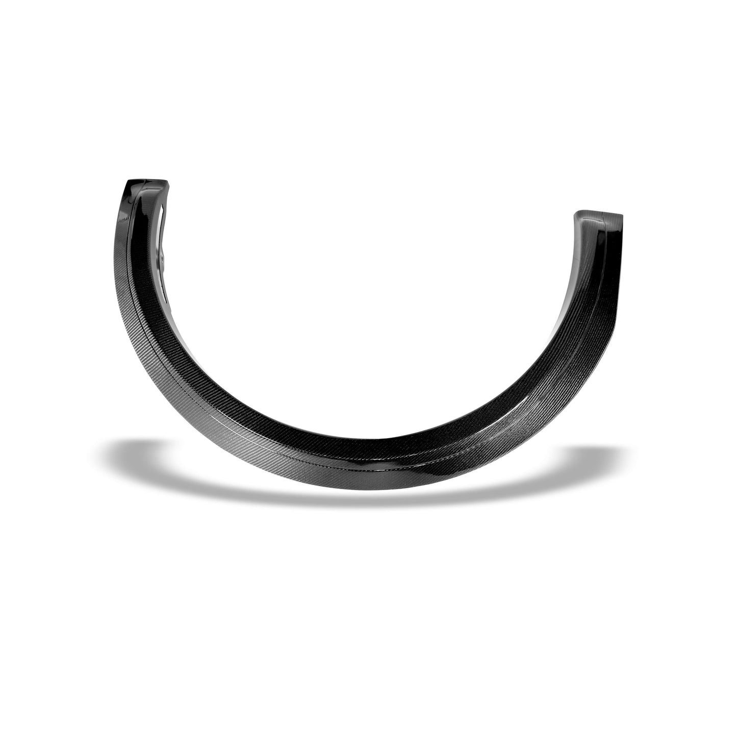 Glossy carbon fiber wheel arch trim catching light on the Model Y facelift